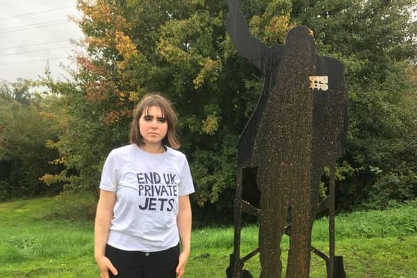 Maddie Budd looks at the camera moments after defacing the memorial of Captain Sir Tom Moore