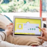 A woman using Snapchat on a tablet. Photo: AdobeStock