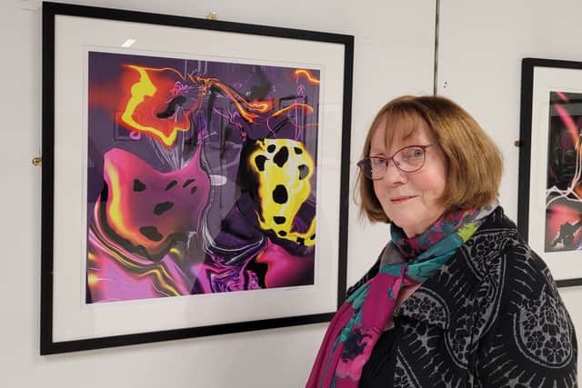 Artist Clare McKee with an example of the digital art at Emmaus Department Store in Rochdale. Credit: Emmaus Department Store