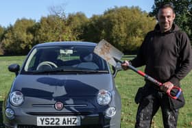Simon Muirhead with his new car after digging up the keys following the instructions from two Manchester colleagues
