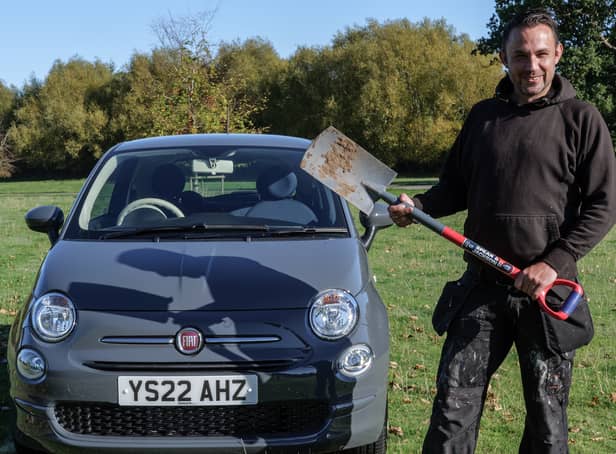 <p>Simon Muirhead with his new car after digging up the keys following the instructions from two Manchester colleagues</p>