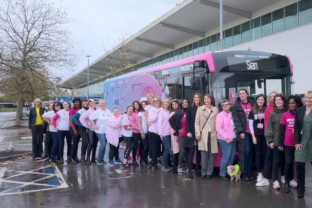 Prevent Breast Cancer officials & ambassadors gathered around the bright pink BooBee bus. 