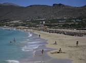 Tourists enjoy the beach in Phalasarna, northwest of the Greek mediterranean island of Crete