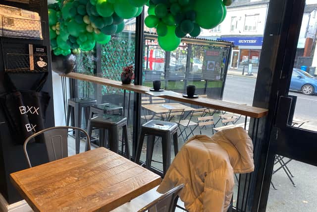The cafe has a relaxed theme with matte black walls and wooden furniture.