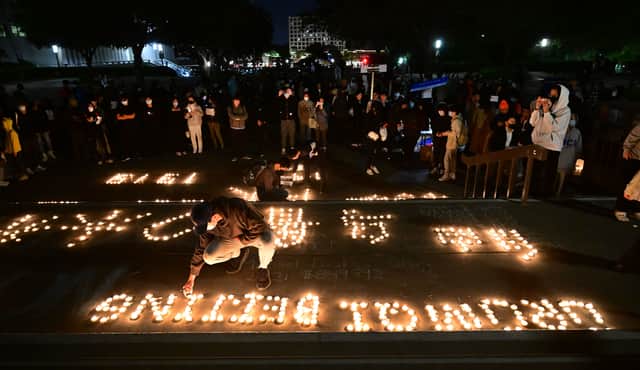 Candles are lit as people protest the deaths caused by an apartment complex fire in Urumqi, Xinjiang, China