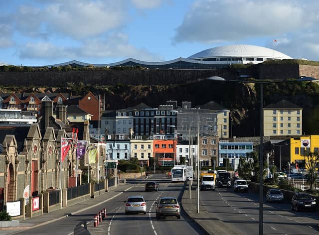 Cars travel by the seafront in St Helier, on the British island of Jersey