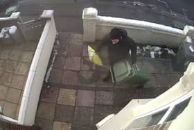 A CCTV camera captured the moment a Christmas parcel was stolen only minutes after an Evri delivery driver bizarrely hid the package under a wheely bin outside the front door. 