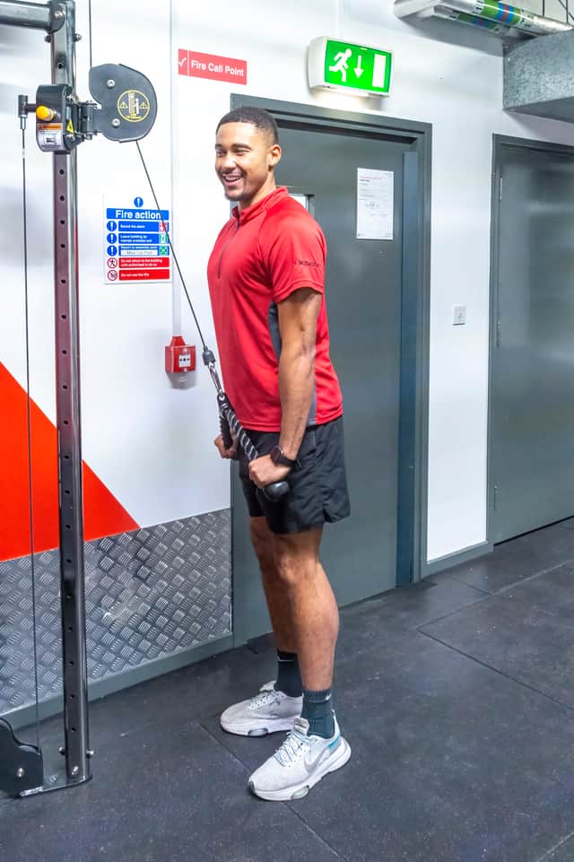 An Everyone Active employee demonstrating the new cable machine at Wythenshawe Forum gym. Credit: Everyone Active