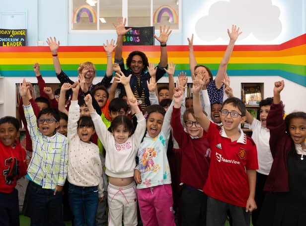 <p>Youngsters and the team at the children’s library in Hulme celebrating its opening. Photo: Lizzie Henshaw</p>