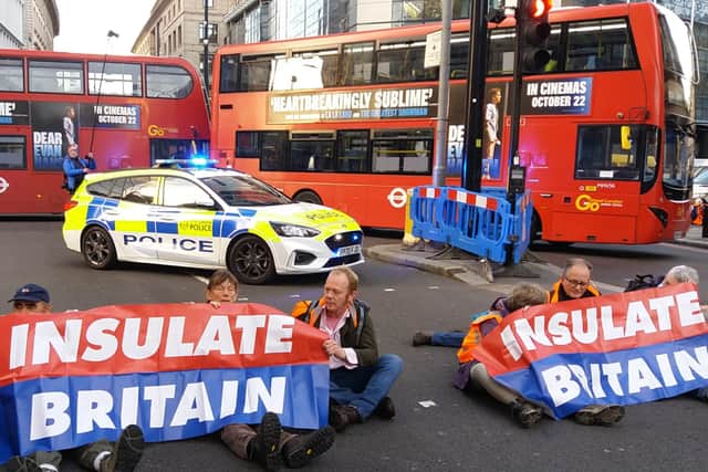 Insulate Britain activists including Rev Jonathan Coleman (second from right) taking part in the roadblock at Bishopsgate in London
