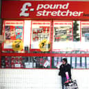 A woman waits outside a branch of Poundstretcher near Lewisham high street.