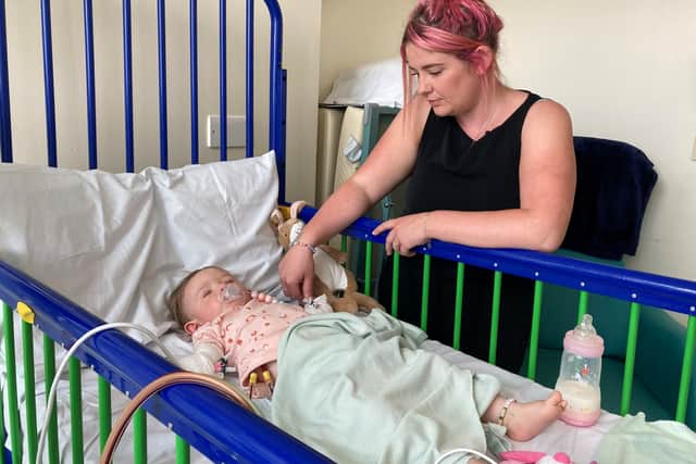 Teddi with mum Ally at her bedside while being treated and cared for at Royal Manchester Children’s Hospital. Photo: BBC