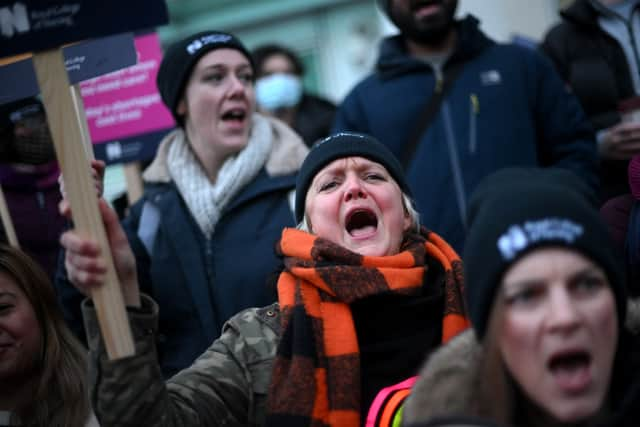 Striking nurses hold signs at a picket line outside University College Hospital in London on January 19, 2023.