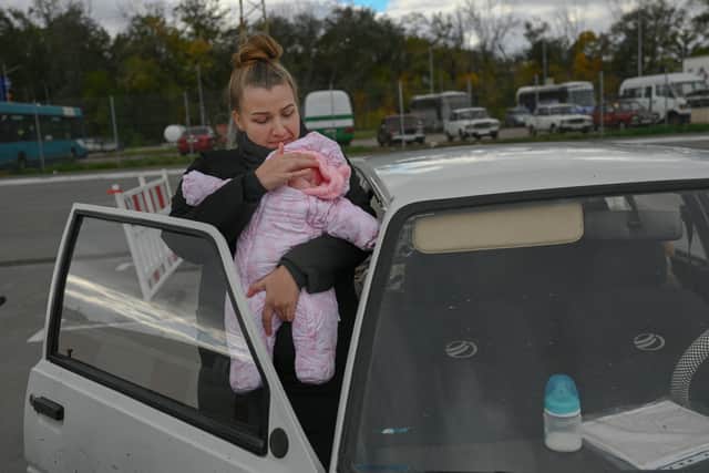 Oleksandra Boyko, a 30-year-old Ukrainian woman from Melitopol, holds her baby at a check point Credit: Getty