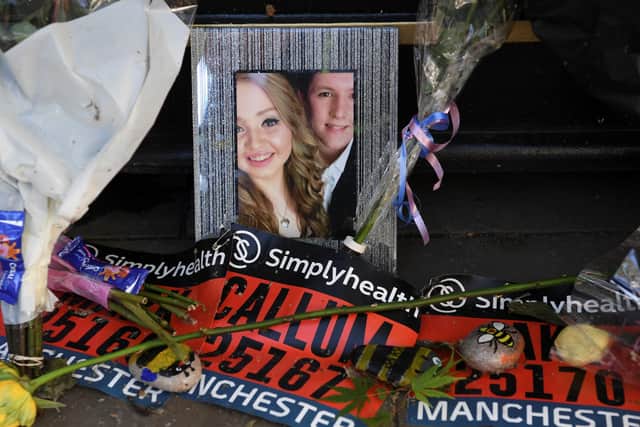 A photo of Liam Curry and Chloe Rutherford among floral tributes at a memorial in Manchester. Photo: AFP via Getty Images