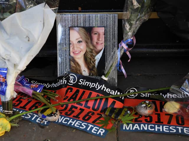 A photo of Liam Curry and Chloe Rutherford among floral tributes at a memorial in Manchester. Photo: AFP via Getty Images