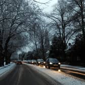 Cars drive on snowy roads.