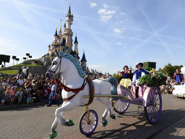 Crowds watch as Snow White and her prince ride past on a carriage during the Main Street Parade at Disneyland Paris.