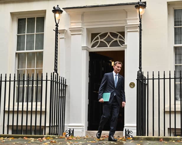 Britain's Chancellor of the Exchequer Jeremy Hunt walks out of Number 11 Downing Street 