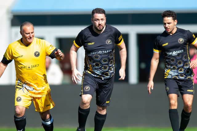 Jason Manford and Adam Thomas playing for the celebrities team with Clayton Blackmore from the legends side. Photo: Manchester Remembers