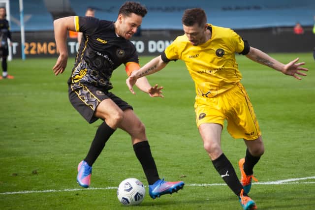 Celebrities player Adam Thomas and Legends player Darren Ambrose vie for the ball