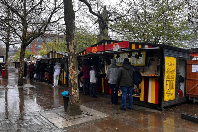 People queue in the rain for Rita’s Reign in Piccadilly Gardens. 