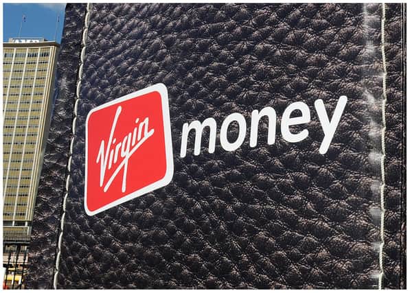 British entrepreneur Richard Branson walks out of a giant wallet as he launches Virgin Money's new credit cards in Sydney Harbour on July 27, 2010. The financial services arm of Branson's Virgin Group now offers Australians low interest rate credit cards, savings accounts, superannuation and car insurance. AFP PHOTO / Torsten BLACKWOOD (Photo by TORSTEN BLACKWOOD / AFP) (Photo by TORSTEN BLACKWOOD/AFP via Getty Images)