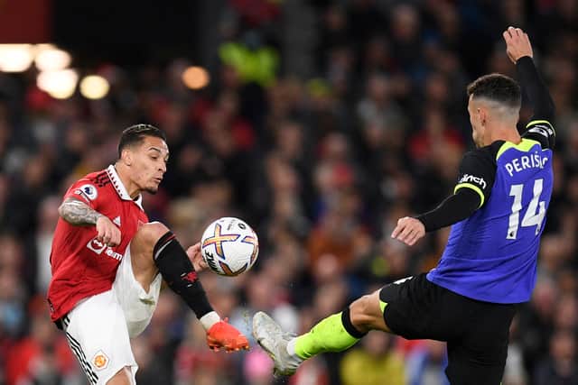 Antony of Manchester United and Tottenham Hotspur’s Ivan Perisic battle for the ball