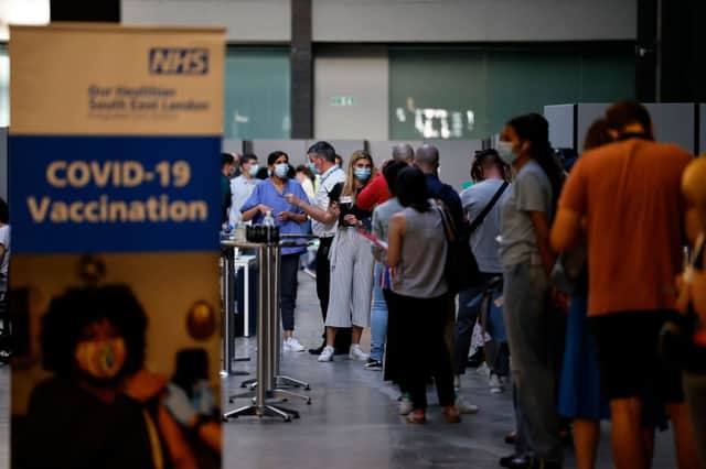 Members of the public queue to receive the Pfizer-BioNTech Covid-19 vaccine in the Turbine Hall at a temporary Covid-19 vaccine centre (Getty Images)