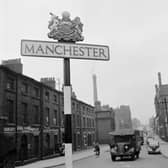 Small textile factories in a street in Manchester, and a road sign with the city's name and crest. circa 1950 (Photo by Three Lions/Getty Images)