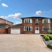 The front of the home has a large driveway with plenty of space for multiple cars