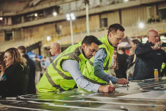 Guests sign the roof cassette as part of the Co-op Live arena’s “topping out” ceremony on 5 July. Credit: Co-op Live