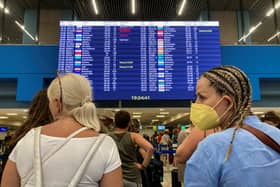 Tourists stand in front of an information board at the airport's departure hall as evacuations are underway due to wildfires, on the Greek island of Rhodes on July 23, 2023. Locals and tourists fled hotspots on Rhodes, as firefighters battled a blaze that had sparked the country's largest-ever fire evacuation. Firefighters were bracing for high winds that have been forecast for the afternoon and that could hamper their efforts. (Photo by Will VASSILOPOULOS / AFP) (Photo by WILL VASSILOPOULOS/AFP via Getty Images)