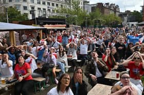 Fans have their heads in their hands in Piccadilly Gardens