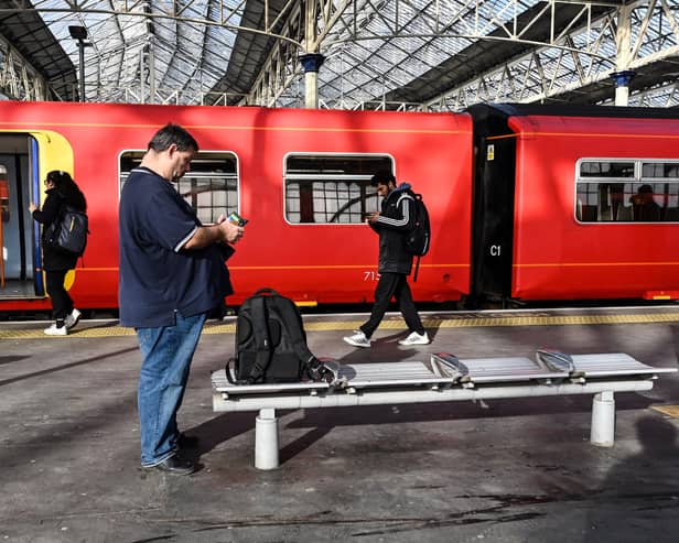 Commuters walk past a train stopped at a platform in Waterloo Station in London, during a national strike day, on February 1, 2023.