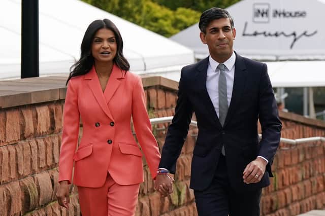 UK Prime Minister Rishi Sunak and his wife Akshata Murty walk to the Main Hall where he will deliver his keynote speech during day four of the Conservative Party Conference on October 4, 2023 in Manchester, England. Rishi Sunak delivers his first speech as Conservative Party Leader to members and delegates today. He is expected to announce the scrapping of the Manchester leg of the HS2 rail link and suggests alternatives. (Photo by Ian Forsyth/Getty Images)