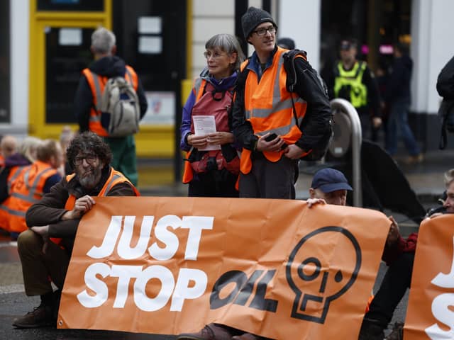 'Just Stop Oil' protesters block the road at the junction of Cannon St and Queen Victoria St on October 27, 2022 in London, England.