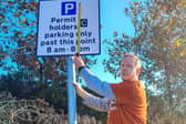 Chris Burton measuring permit holders sign, after finding the 'blue P' was 6cm short of 20cm requirement.