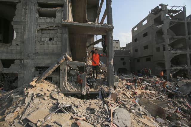 Palestinians check the destruction in the aftermath of an Israeli strike in Jabalia 