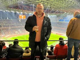 Andy Bebbington, pictured at a game in Milan, flew 8,000 miles from China to see Bolton at Cambridge - only for the game to be abandoned due to a waterlogged pitch.