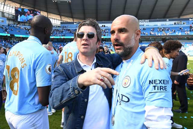 Noel Gallagher speaks to Josep Guardiola, Manager of Manchester City on the pitch after the Premier League match between Manchester City and Huddersfield Town at Etihad Stadium on May 6, 2018 in Manchester, England. (Photo by Michael Regan/Getty Images)