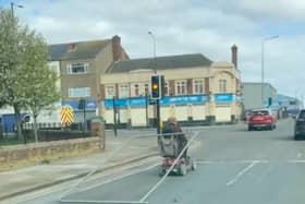 A man tows a metal fence from his mobility scooter in Grimsby. The man was spotted dragging the fence along as he stopped at traffic lights.