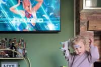 Sonny Coulson, 2, practices his Gladiator poses in front of the TV. Picture: Dave Coulson/SWNS