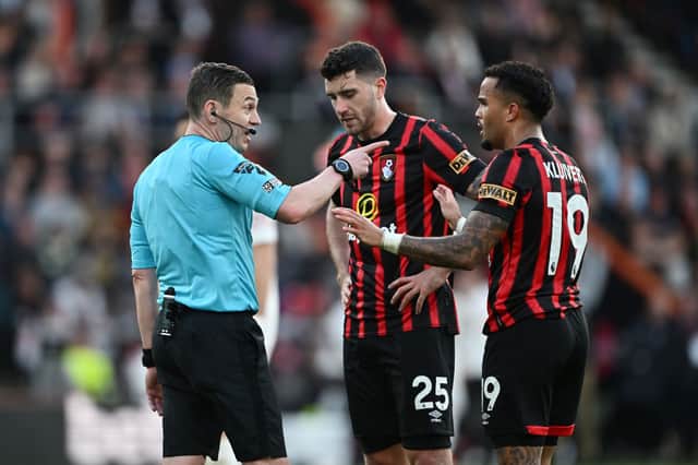 Referee Tony Harrington speaks to Marcos Senesi and Justin Kluivert of AFC Bournemouth