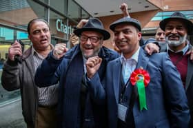 George Galloway arrives to congratulate fellow Workers Party of Britain candidate Shahbaz Sarwar (second right) during the Manchester city council election results on May 3. Credit: William Lailey / SWNS