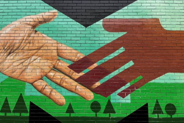 The artistic styles of Akse P19 and Stanley Chow come together in their mural on the CityLink walking route between Manchester city centre and the Co-op Live arena.