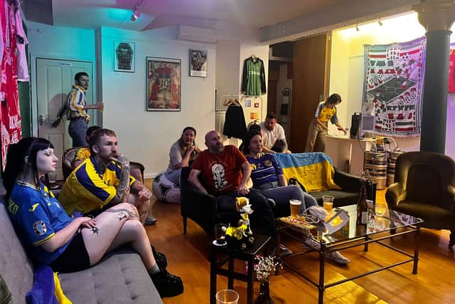 Ukraine fans watch the national team's group match against Slovakia in the 2024 Euros at Stunner vintage football shirt shop in Manchester. 