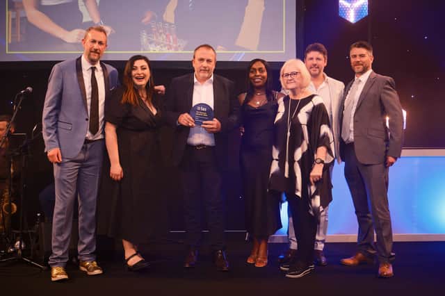 Staff from Burnage Academy for Boys receive their award for Secondary School of the Year at the Tes Schools Awards 2024, hosted by Taskmaster's Alex Horne. Credit: Tes