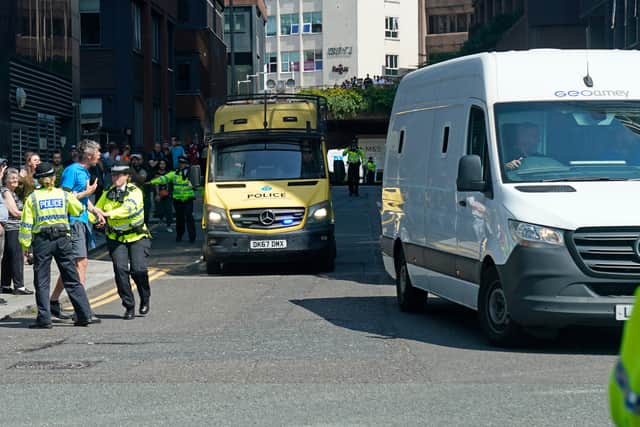A man is held back by police as a prison van escorted by multiple police vehicles leaves Liverpool Crown Court where 17-year-old Axel Rudakubana was remanded into youth detention accommodation. Credit: Danny Lawson/PA Wire