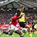 Kobbie Mainoo of Manchester United is challenged by Sander Berge of Burnley